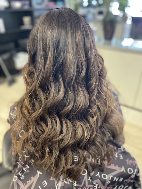 Elegant layered haircut styled with personalized technique by Elaina.